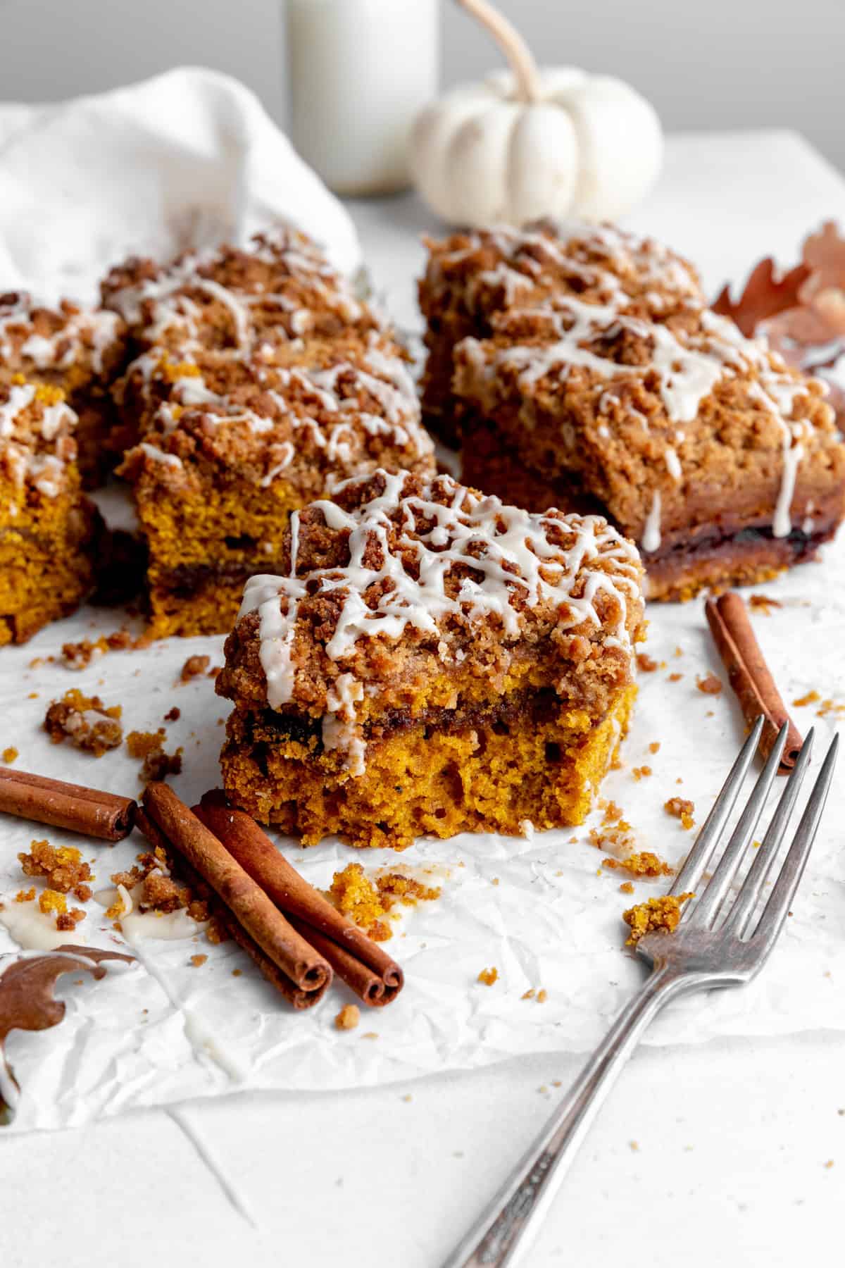 Slice of pumpkin coffee cake, cinnamon sticks and a fork.