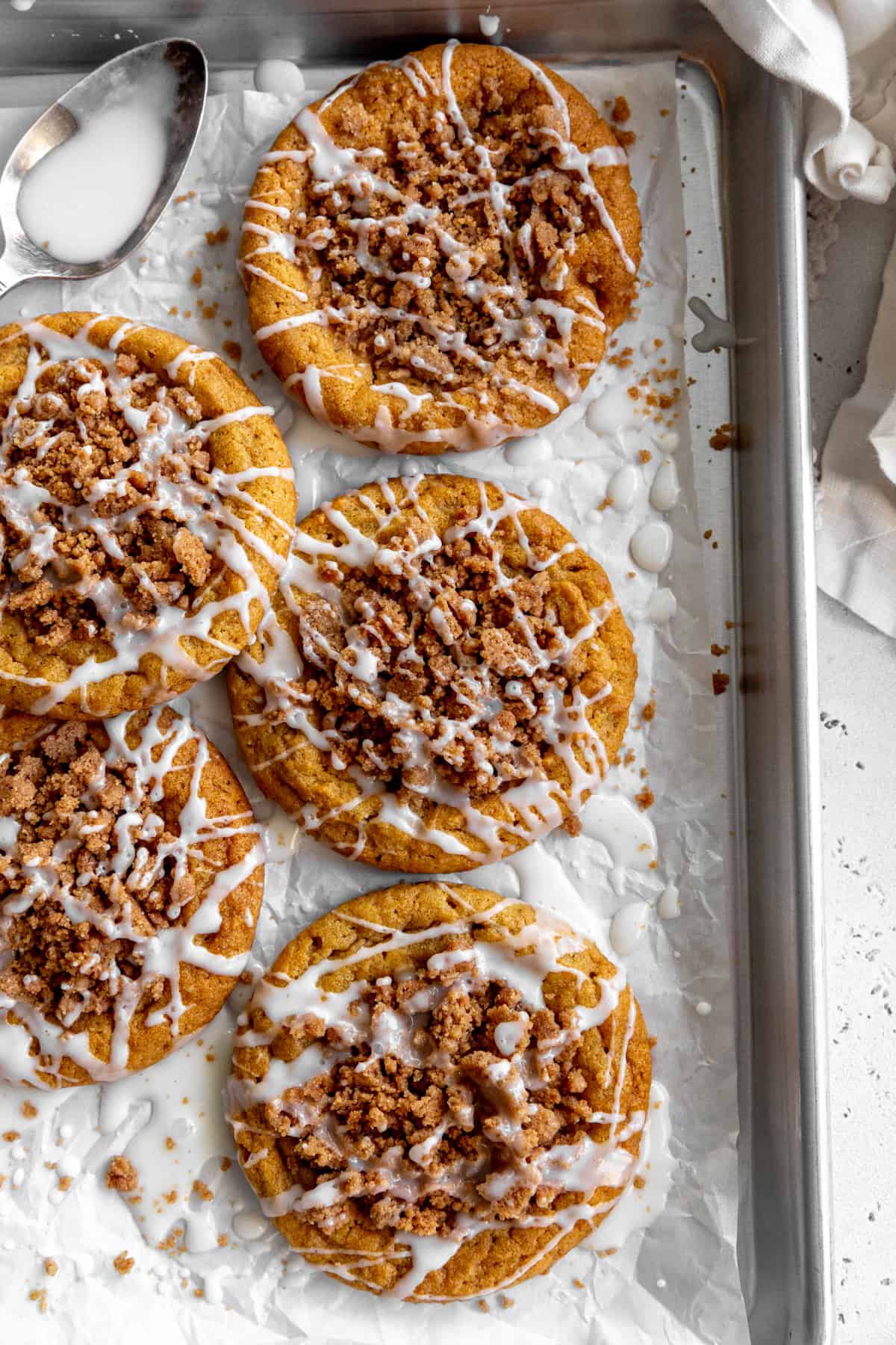 Pumpkin coffee cake cookies on a baking sheet and a linen napkin.