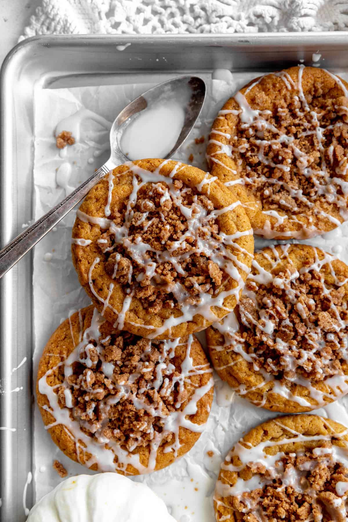 Pumpkin coffee cake cookies and a spoon covered in sweet glaze.