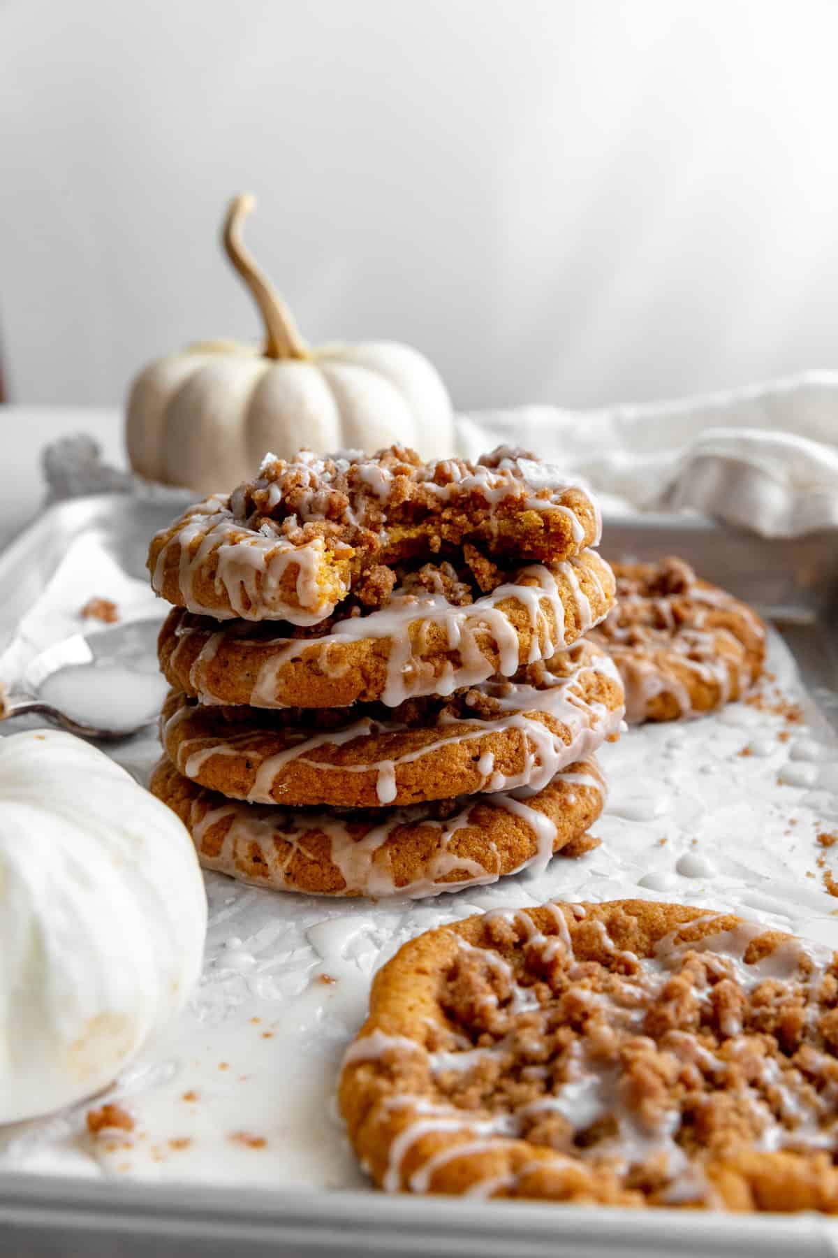 Stack of pumpkin coffee cake cookies and a white pumpkin.