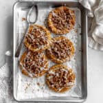 Pumpkin coffee cake cookies on a baking sheet and a white linen napkin.
