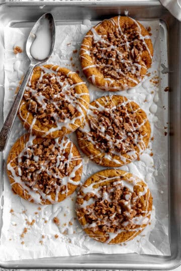 Pumpkin coffee cake cookies on a baking sheet and a white linen napkin.