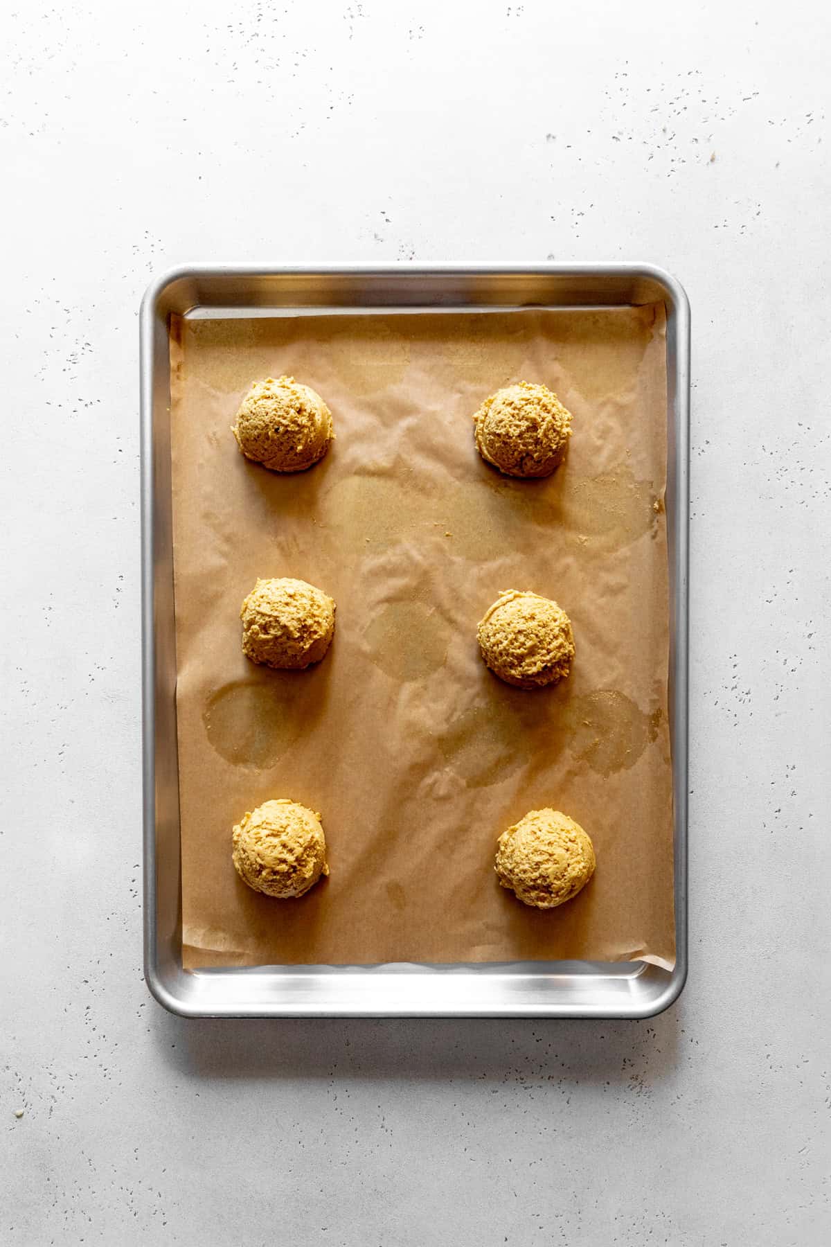 Unbaked pumpkin cookies on a baking sheet.