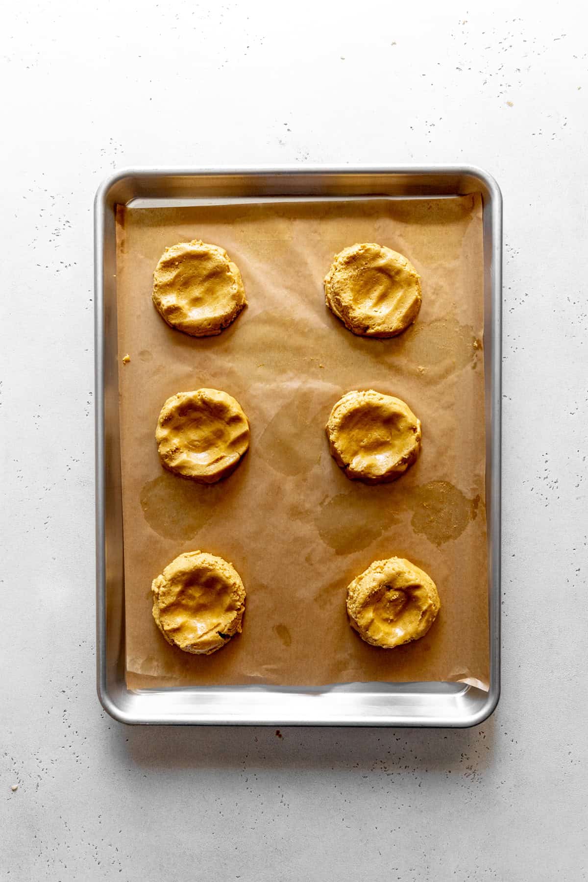 Hollowed out pumpkin cookies and a baking sheet.