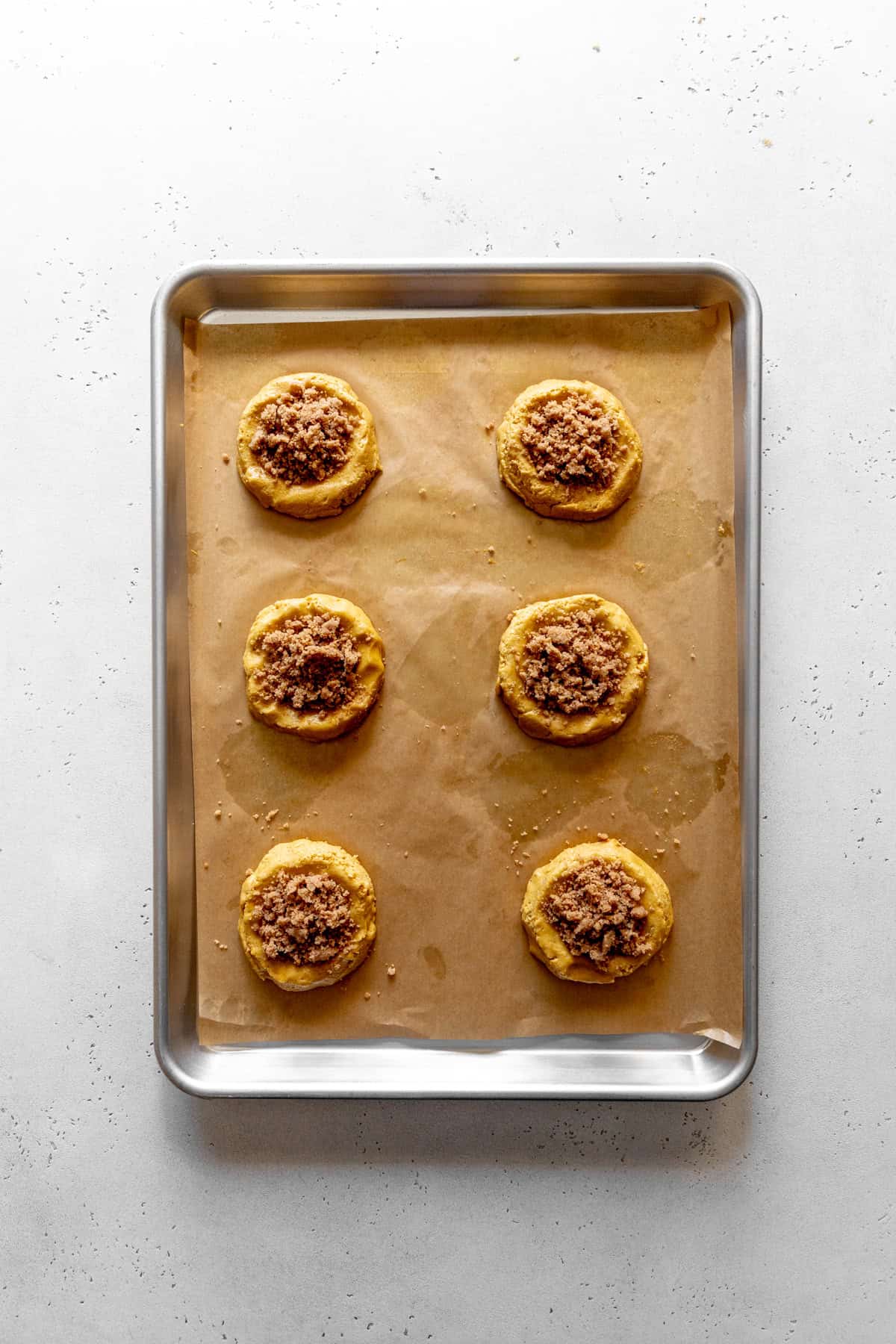 Streusel-filled pumpkin cookies on a baking sheet.