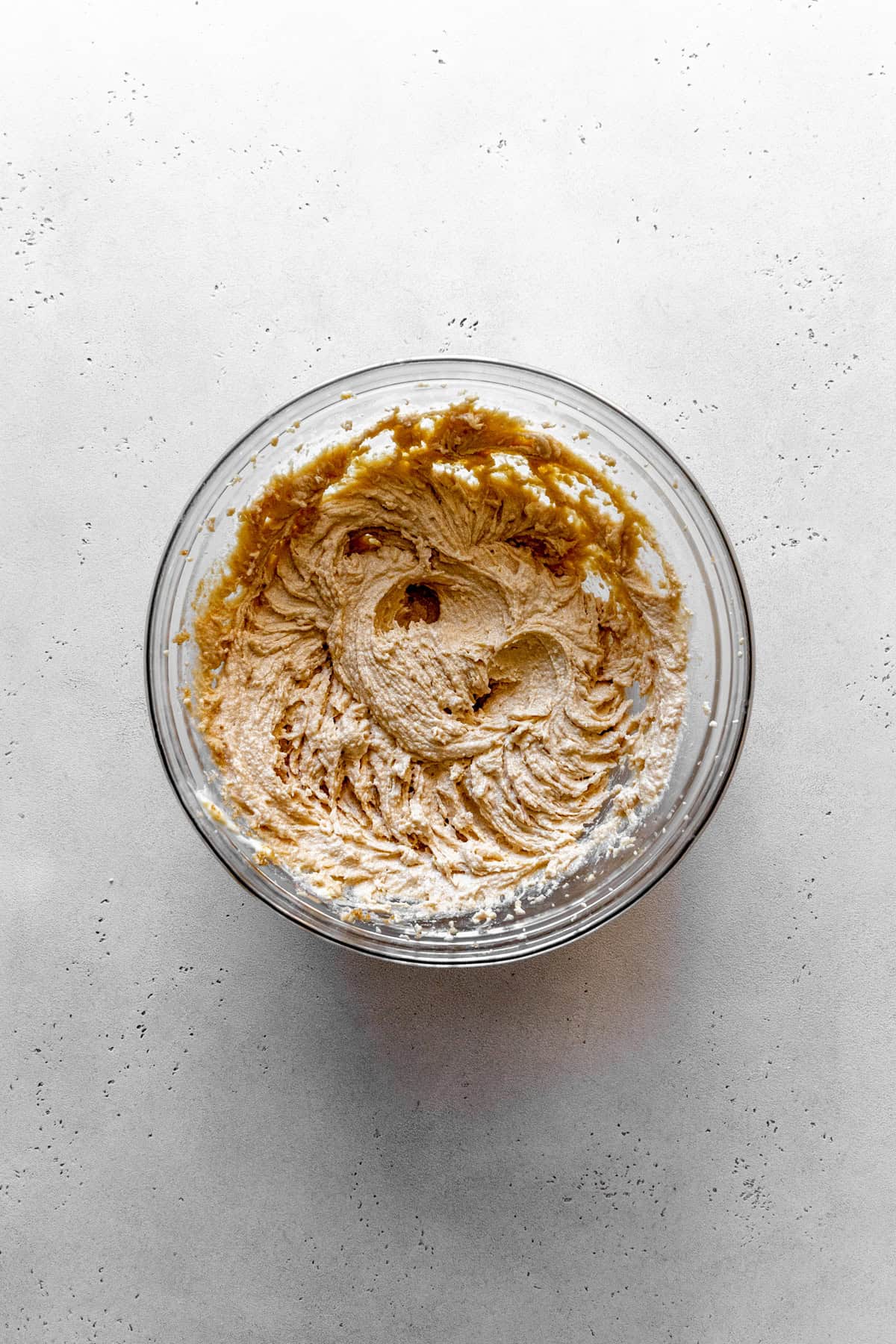 Creamed butter and sugar in a glass bowl.