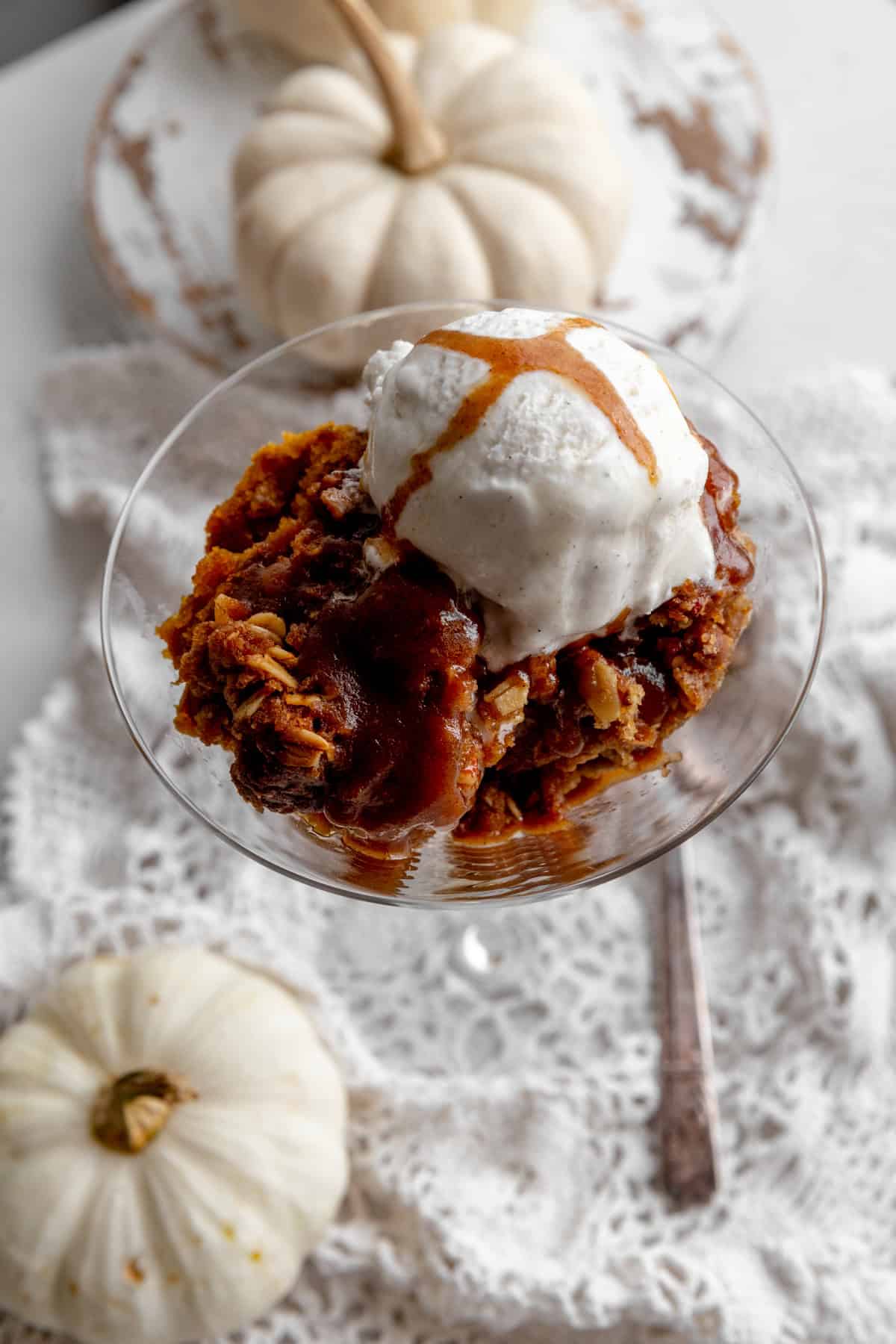 Pumpkin crisp topped with vanilla ice cream and white pumpkins.
