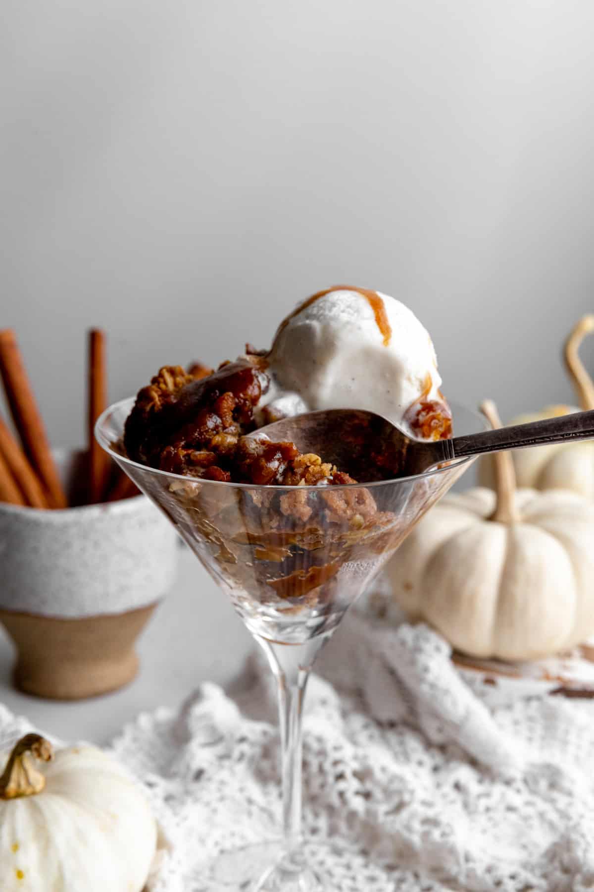 Spoon digging into pumpkin pecan crisp.