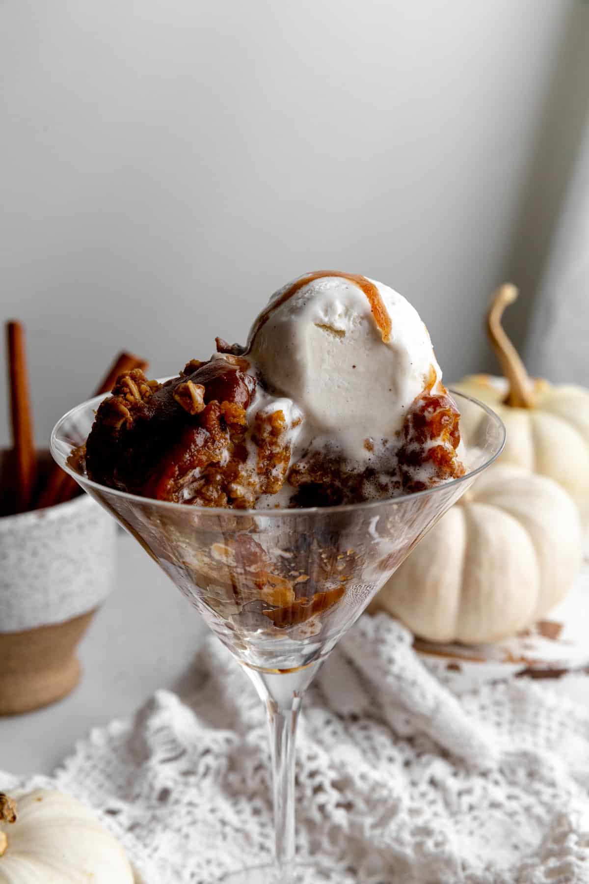 Vanilla ice cream melting over pumpkin pecan crisp.